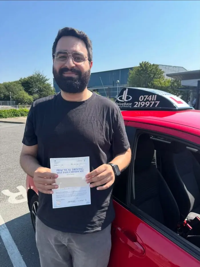Aditya with their driving test pass certificate beside the DriveBase car