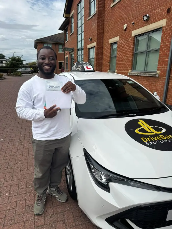 Opeyemi Odedeyi with their driving test pass certificate beside the DriveBase car